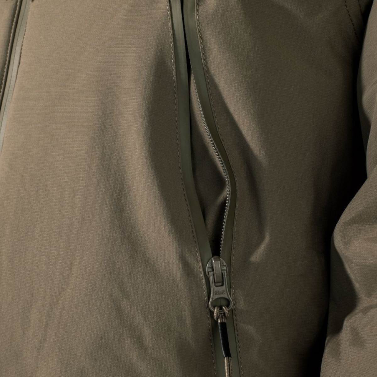 Close-up of the olive green Adversary Force AB Jacket ECW Level 7 showing the durable nylon ripstop and zipper detail.