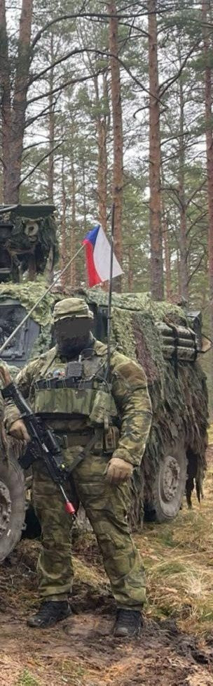 Adversary Force L4 WCSIG Chest Rig in Tarnmuster getragen von einem Soldaten vor einem getarnten Militärfahrzeug im Wald